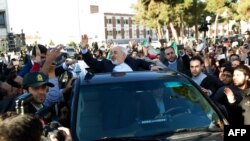 Швейцариядагы сүйлөшүүдөн кайтып келген Ирандын тышкы иштер министри Зарифти аэропортто котологон эл тосуп алды. 3-апрель, 2015-ж. Тегеран ш.