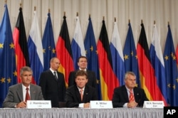 Володимир Путін та Ґергард Шредер стоять позаду Олексія Міллера (в центрі), Юрґена Гамбрехта (ліворуч) та Вульфа Бернотата (праворуч) під час церемонії підписання документів про енергетичне співробітництво між Росією та Німеччиною. Берлін, вересень 2005 року