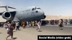 Кабулдагы аэропортто АКШнын аскердик учагынын жолун тосууга аракет кылган ооган жарандар.  16-август, 2021-жыл.