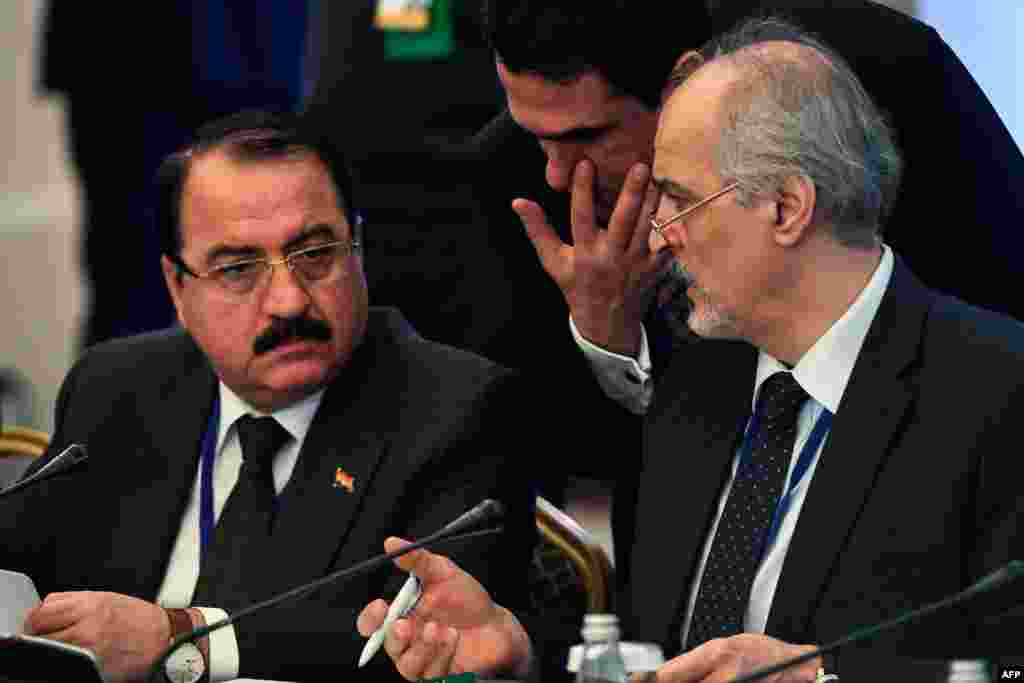 Представитель Сирии в ООН и глава сирийской правительственной делегации Башар аль-Джафари (справа) беседует с послом Сирии в России Риадом Хаддадом.