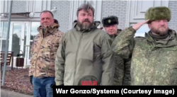 Володимир Алексєєв (у центрі, за спинами) та Олексій Кондратьєв (праворуч) на з’їзді найманців «Добровольчого корпусу» в окупованому Маріуполі у 2023 році