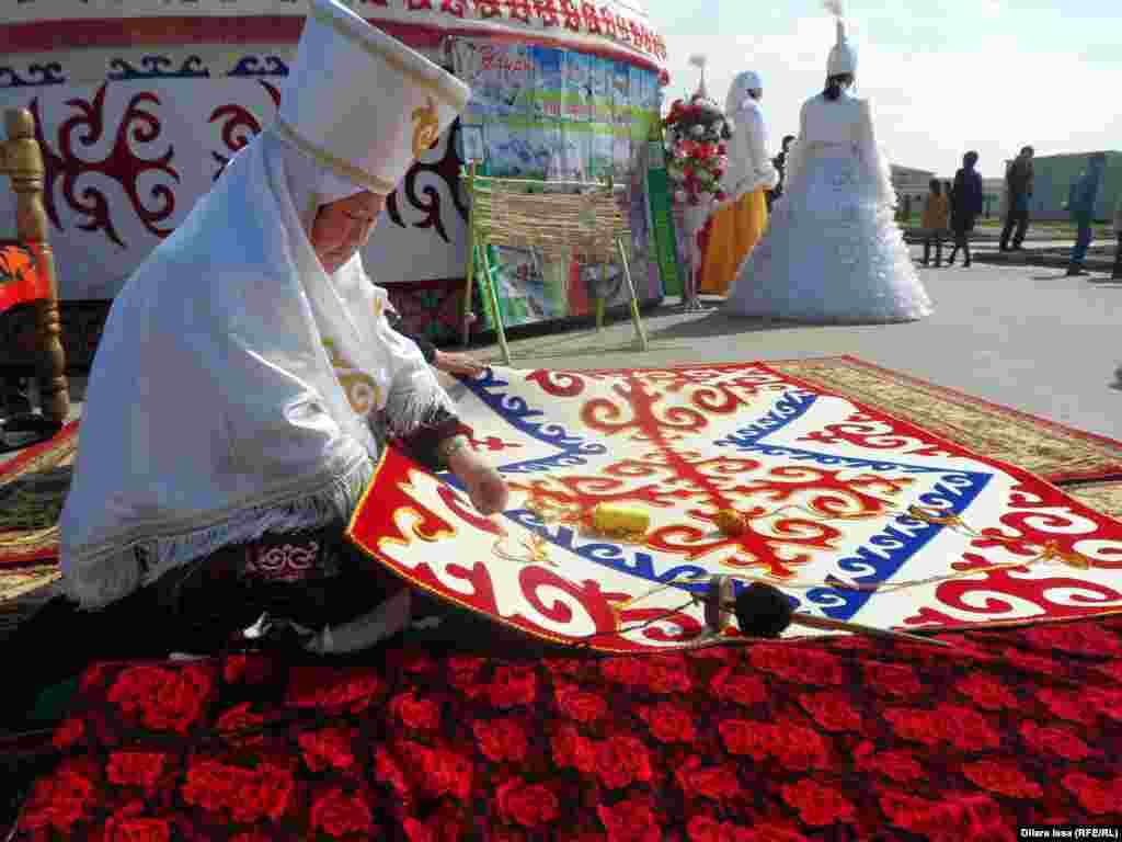Женщина за изготовлением сырмака (вышитый ковер из кошмы).
