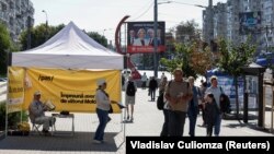 Учасники кампанії владної партії «Дія і солідарність» (PAS) роздають листівки перед майбутніми парламентськими виборами в Молдові, Кишинів, 21 вересня