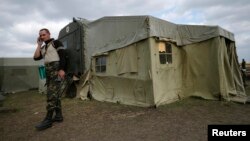 Український військовий розмовляє по телефону біля польового шпиталю у Сватові, вересень 2014 року