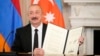 U.S. - Azerbaijan President Ilham Aliyev holds a signed trilateral agreement during a ceremony with Armenian Prime Minister Nikol Pashinian and President Donald Trump at the White House, August 8, 2025.