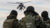 Українські прикордонники спостерігають як російський гелікоптер Мі-35 пролітає поряд з кордоном України з Росією, Херсонська область, 16 березня 2014 року