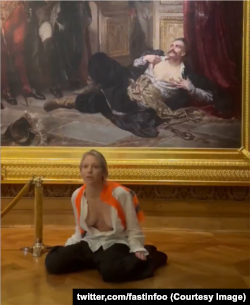 Актывістка перад карцінай з Тадэвушам Рэйтанам