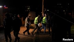 Співробітники екстреної служби несуть тіло на місці російського ракетного удару в житловому районі, Кривий Ріг, Україна, 4 квітня 2025 року