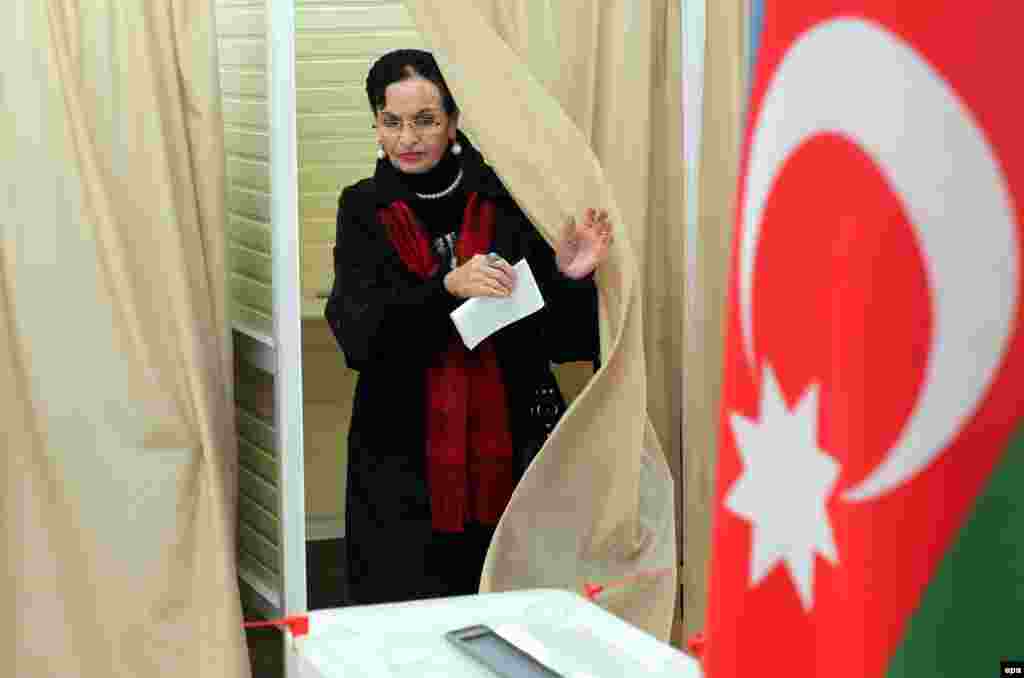 A woman leaves a voting booth at a polling station in Baku.