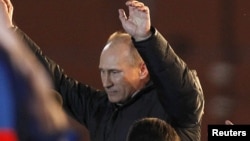 Владимир Путин приветствует своих сторонников на митинге на Манежной площади. Москва, 4 марта 2012 года.    