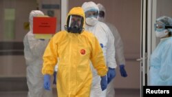 Президент Росії Володимир Путін, одягнений у захисний одяг жовто-синього кольору, в лікарні для пацієнтів, інфікованих коронавірусом. 24 березня 2020 року