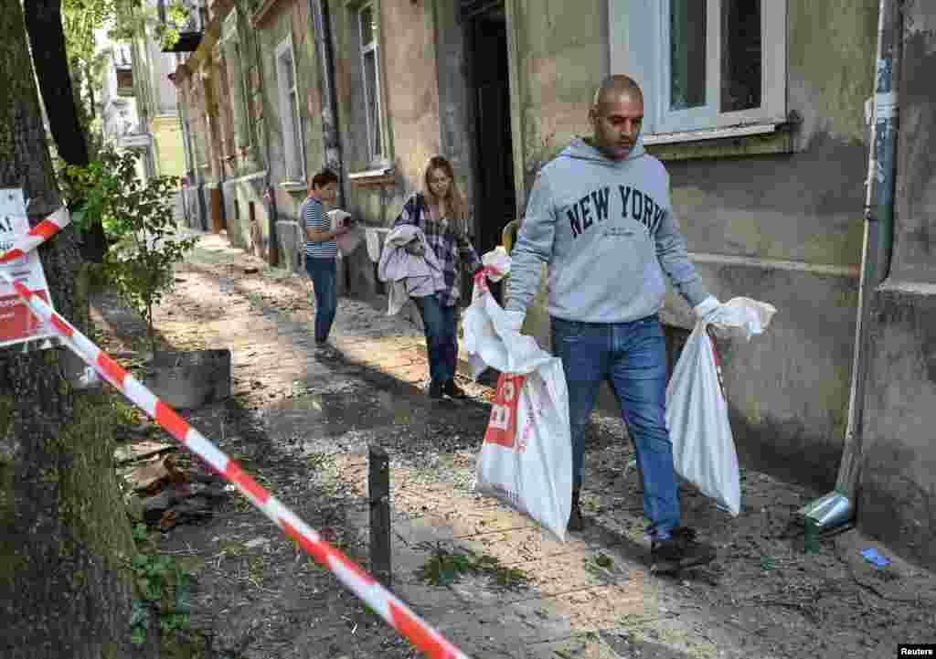 Люди прибирають на місці удару. Львів, 21 серпня