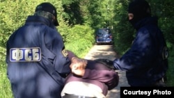 Орусиянын ФККсынын кызматкерлери террорчулук үчүн шектүү деп эсептелген кишини кармаган учур. 6-июль, 2013-жыл.