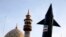 A model of a missile is carried by Iranian demonstrators as a minaret and dome of a mosque is seen in the background during an anti-Israeli rally in Tehran on April 15.