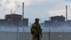 A soldier with a Russian flag on his uniform stands guard near the Zaporizhzhya nuclear power plant on August 4.