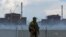 A soldier with a Russian flag on his uniform stands guard near the Zaporizhzhya nuclear power plant on August 4.