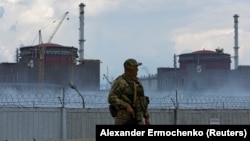 A soldier with a Russian flag on his uniform stands guard near the Zaporizhzhya nuclear power plant outside the Russian-controlled city of Enerhodar on August 4. 
