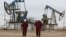 Workers walk near oil pumps at the Uzen oil and gas field in the Mangistau region of Kazakhstan. (file photo)
