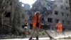 Workers clean up outside a building destroyed as a result of Russian shelling in Mykolayiv on August 2.