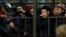 Migrant workers line up in a fenced holding area outside a Federal Migration Service office in Moscow as they wait for their turn to get a work permit.