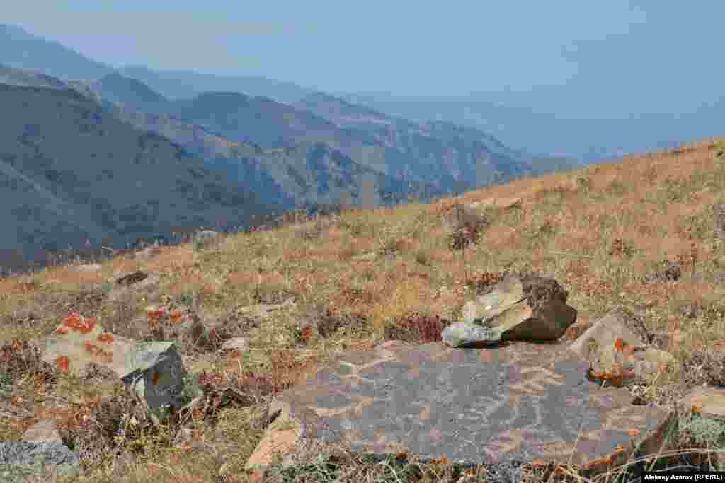 Древние наскальные рисунки встречаются уже на склоне горы Рахат. На обратном пути, 23 сентября, корреспондент Азаттыка, спускаясь с вершины Рахата после тренировочного подъема на эту гору, обнаружил на южном склоне этот камень с множеством петроглифов.