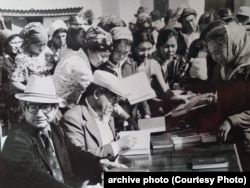 Чыңгыз Айтматов окурмандарга кол тамга коюп берүүдө.