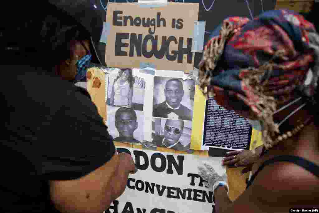 Венді Лонг, ліворуч, та сестра Меймі, наліплюють написи зняті з огорожі парку Лафайєтт, що неподалік Білого дому у Вашингтоні,&nbsp;де відбувалися протести. Демонстрації розпочалися через смерть Джорджа Флойда, чорношкірого чоловіка, який помер під час затримання поліцією в Міннеаполісі 25 травня 2020 року