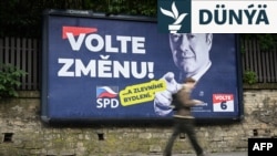 Pyýada çehleri ​​"üýtgeşiklige ses bermäge" çagyrýan aşa-sagçy partiýa üçin taýýarlanan saýlaw plakatynyň öňünden geçip barýar.