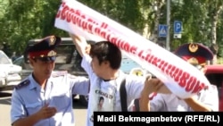 Участника акции в защиту бастующих нефтяников задерживает полиция. Алматы, 17 августа 2011 года.   