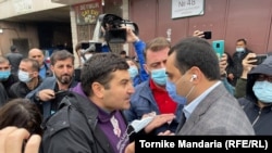 Оппозициялык "Бирдиктүү улуттук кыймыл" партиясынын өкүлү Георгий Мумладзе жана  бийликтин "Грузин кыялы" партиясынын өкүлү Заур Даргали (алдыңкы планда) №48 шайлоо участогунда чыккан чырдан кийин.  2-октябрь, 2021-жыл.
