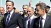 Fransiýanyň prezidenti Nikolas Sarkozi we Britaniýanyň premýer-ministri Deýwid Kameron Liwiýanyň Milli Geçiş Geňeşiniň başlygy Abdel Jelil bilen bilelikde ýerli medisina merkezine sapar edýarler. Tripoli. 15-nji sentýabr, 2011.