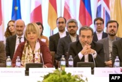 Ирандын ТИМинин орун басары Аббас Арагчи (оңдо) жана Евробиримдиктин Тышкы иш-аракет кызматынын Башкы катчысы Хелга Шмид (солдо) “БААПтын” отурумунда. (Ага Германия, Иран, Кытай, Орусия, Улуу Британия жана Франция катышты). Вена ш., Австрия. 2019-жылдын 28-июну.