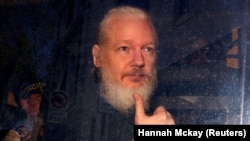 Жулиан Ассанждын полиция алып кетип бара жатканда тартылган сүрөтү. 11-апрель, 2019-жыл. 