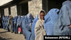 آرشیف- زنان بیوه در صف برای دریافت کمک ایستاده اند. 