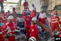 Қизил ярим ой жамияти қутқарувчилари Теҳрондаги вайроналар ичида ишлашяпти. 17 июн, 2025 йил.