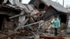 A woman stands near the debris of her house following Russian shelling in the Donetsk region on December 