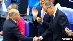 Вече бившият канцлер на Германия Олаф Шолц (вляво) поздравява своя наследник на поста Фридрих Мерц.