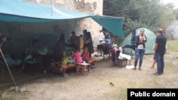 Өртенген үйдің тұрғындары шатырларының маңында отыр. Алматы, 18 тамыз 2014 жыл. Сурет Искандер Раимов атты интернет қолданушының Facebook парақшасынан алынды.  