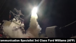 АКШ кемеси Хан-Шейхун чабуулунан кийин Сириянын аба базасына ракеталык сокку урган учур. 7-апрель, 2017-жыл.