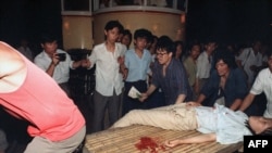 4-июнда аскерлер менен студенттер ортосундагы кагылышууда жарадар болгон кыз арабага жүктөлүп баратат. 1989-жыл. Бээжин.