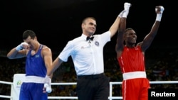 Казахстанский боксер Адильбек Ниязымбетов (слева) в момент, когда рефери объявляет победителем финального боя кубинца Хулио Сесара Ла Круса (справа). Рио-де-Жанейро, 18 августа 2016 года.