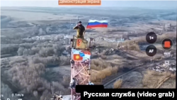 Российский солдат водружает российский флаг над Малой Локней в Курской области