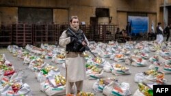 سرباز طالبان در حال محافظت از بسته های امدادی - تصویر از آرشیف 