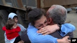 Armenia - Ethnic Armenians who fled Nagorno-Karabakh embrace upon their arrival in Kornidzor, September 26, 2023. (Stepan Poghosyan/PHOTOLUR Photo via AP)