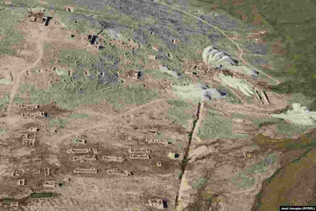 Сүрөттө: Певек шаарынын чыгышындагы дагы бир кен комплексинин көрүнүшү. Бул аймактагы уран иштетүүчү ишкана 1950-жылдардын башында жабылган менен радиактивдүү калдыктар кала берген. Бул таштанды жайлары бүгүн да ачык турат жана андагы радиациянын деңгээли өтө жогору экендигин айтышат.