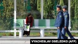 Aşgabadyň awtobus duralgalarynyň birinde oturan talyp gyz we polisiýa işgärleri (Illýustrasiýa suraty)