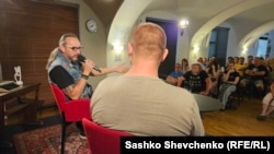 Чеський журналіст Якуб Санто (зліва) модерував бесіду із Маком, чиє обличчя приховане з міркувань безпеки