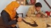 طاهره فهیمی و محسن جعفری در کارگاه هنری حکاکی شان در ولایت بامیان