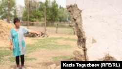 Житель села Казатком Гульбаршин Иманбаева показывает угол дома, обвалившийся в результате землетрясения. Алматинская область, 6 мая 2011  года.