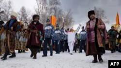 Сочиге бара жатқан олимпиада алауын ұлттық костюм киген адамдар қоршап келеді. Иркутск, 23 қараша 2013 жыл.  